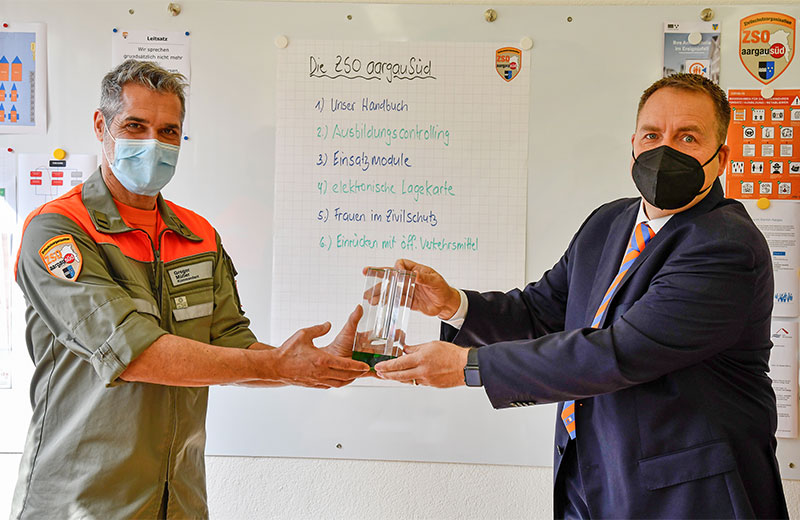 SZSV-Vorstandsmitglied Michel Elmer (rechts) übergibt den Pokal an Kommandant Gregor Müller